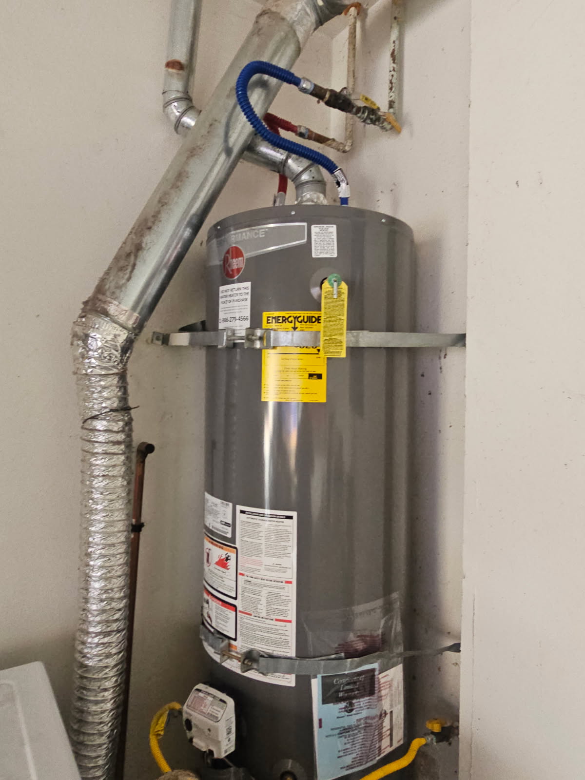 Rheem 50-gallon gas water heater installed with seismic strapping in a Northridge garage